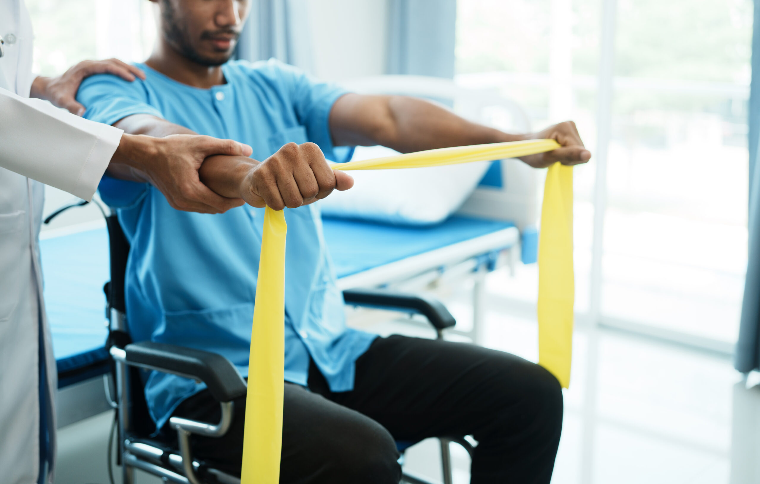 Asian male physical therapist working with patient doing stretch